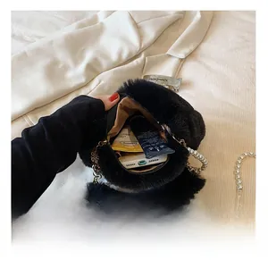 Interior view showing the capacity of a black faux fur bag with a pearl chain strap