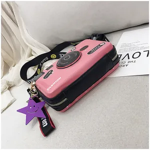 Macro detail of camera-shaped bag with pink and black PU leather and wide smile strap