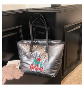 Détail d'un sac cabas argenté matelassé avec broderie Merry Christmas et anses en cuir