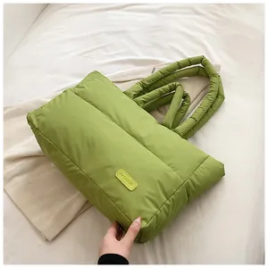 Détail du sac cabas matelassé vert avec étiquette en cuir et poignées rembourrées
