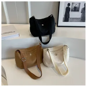Detailed view of minimalist canvas crossbody bags in black, brown and beige colors