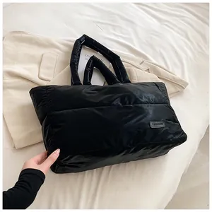 Détail macro du sac cabas matelassé noir avec logo mode sur fond de tissu doux