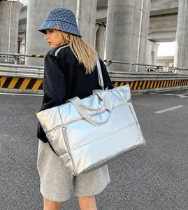 Detail of silver metallic travel bag showing padded texture and adjustable strap
