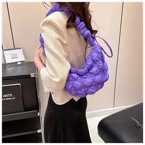 Primer plano del bolso nube violeta acolchado con textura plisada y correa de hombro