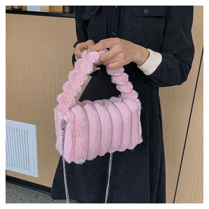 Detail of pink plush crossbody bag with stripe texture and spherical handle strap