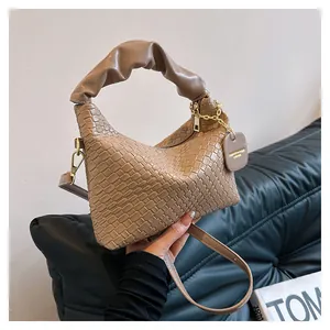 Détail de la texture tressée marron et de l'anse froncée sur un sac à main élégant