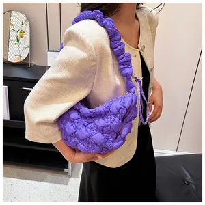Primer plano del bolso nube acolchado morado con detalles de correa fruncida y plisada