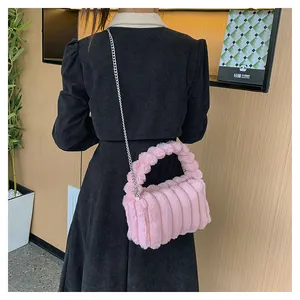 Detail of light pink plush handbag with striped texture and woven handle on model