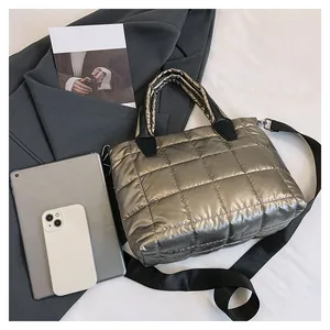 Dettaglio della borsa trapuntata argento con tracolla nera su uno sfondo di stile moderno