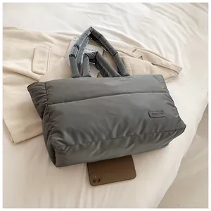 Détail du sac cabas gris matelassé en nylon avec téléphone portable pour comparer la taille