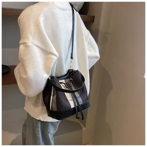 Detail of vintage striped bucket bag with woven canvas and black leather trim