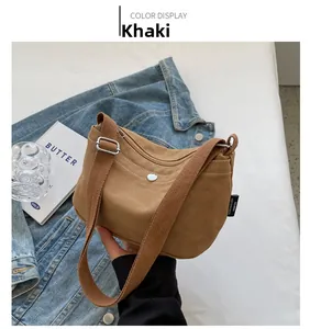 Close-up of khaki canvas crossbody bag featuring a metal buckle and adjustable strap