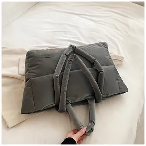 Détail du sac cabas matelassé gris foncé avec texture rembourrée et poignée souple