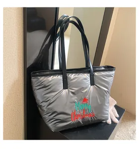 Détail du sac cabas matelassé argenté brillant avec broderie Merry Christmas et anses noires