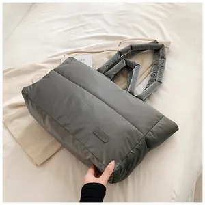 Gros plan détaillé du sac cabas matelassé gris foncé avec étiquette mode sur tissu doux