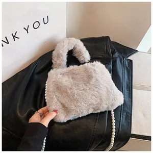 Detailed close-up of light gray faux fur handbag with elegant pearl chain strap and handle