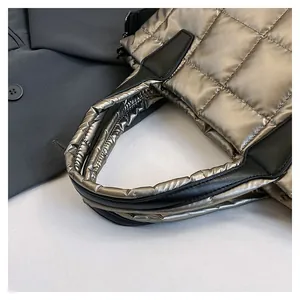 Dettaglio della borsa trapuntata champagne metallizzato con manici imbottiti e pelle