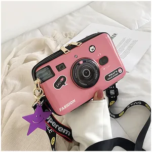 Pink camera-shaped crossbody bag with a fashion lens design and a star charm