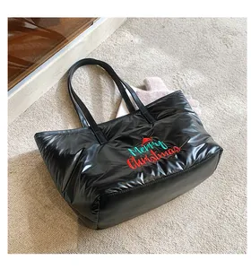 Gros plan d'un sac cabas noir matelassé avec broderie festive de Merry Christmas