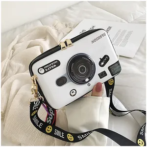 Fashion camera-shaped crossbody bag with a white hard shell and smiley face wide strap