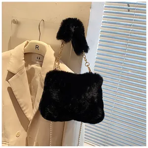 Detail of plush black crossbody bag featuring gold metal chain and elegant pearl tassel