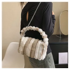 Detail of plush striped handbag with silver chain strap on a white chair setting