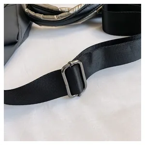 Dettaglio della tracolla in nylon nero con fibbia regolabile in metallo canna di fucile