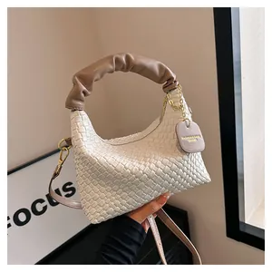 Détail du cuir tressé blanc avec poignée plissée marron et étiquette en cuir