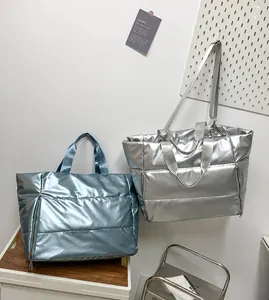 Detail of metallic quilted tote bags in blue and silver with textured padded fabric