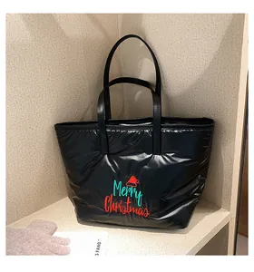 Détail d'un grand sac cabas noir matelassé avec broderie Merry Christmas et nylon brillant