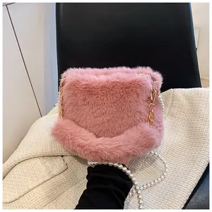 Detailed close-up of pink faux fur crossbody bag with pearl strap and gold chain