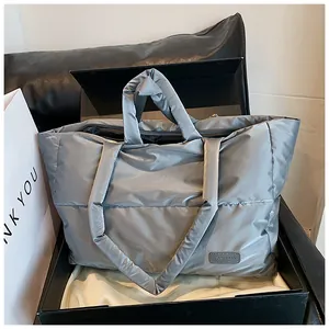 Vue détaillée du sac cabas matelassé argenté dans un coffret cadeau noir de qualité