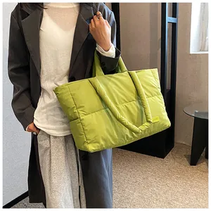 Détail du sac cabas matelassé vert vif avec un écusson en cuir au style tendance