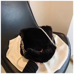 Detail of black faux fur shoulder bag featuring elegant pearl and gold chain strap