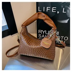 Détail du sac à main en cuir tressé marron foncé avec poignée plissée et chaîne dorée