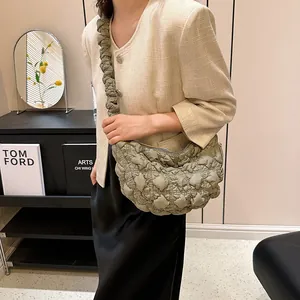 Bolso de hombro nube verde aguacate con textura plisada usado por una modelo mujer