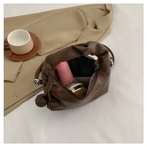 Detailed interior of minimalist brown tote bag showing compartments and daily essentials
