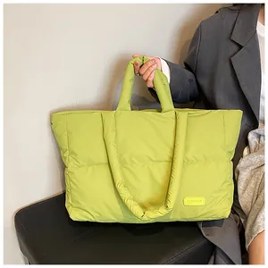 Détail du sac fourre-tout matelassé vert fluo avec étiquette FASHION et texture puffer