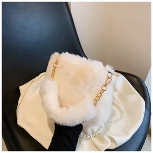 Detail of white plush shoulder bag featuring premium faux fur and golden metal chain strap