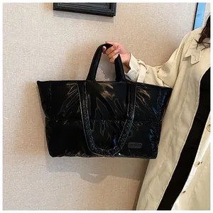 Gros plan du sac cabas matelassé brillant montrant l'étiquette et la texture noire
