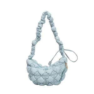 Bolso nube acolchado azul claro con correa plisada y cremallera dorada sobre fondo blanco