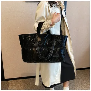 Gros plan d'un grand sac cabas noir matelassé en nylon brillant avec étiquette Fashion