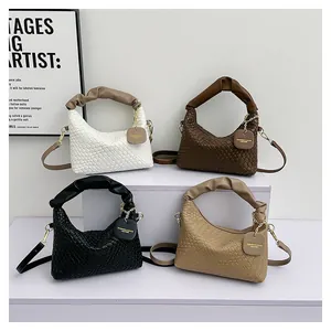 Vue détaillée de sacs à main en cuir tressé en blanc, marron et noir sur un présentoir