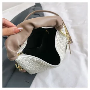 Détails de l'intérieur du sac tressé blanc montrant la doublure noire et l'espace de rangement