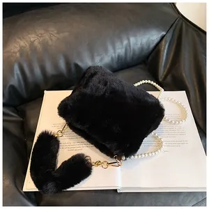 Close-up of black faux fur bag featuring a glossy pearl chain strap and soft plush texture