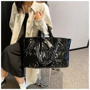 Vue détaillée du grand sac cabas matelassé noir brillant avec écusson fashion