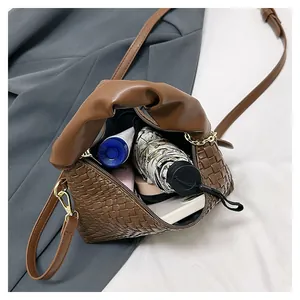 Détail du sac à main tressé marron montrant la capacité pour téléphone et accessoires