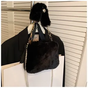 Detail of plush faux fur handbag with elegant pearl metal chain and soft top handle