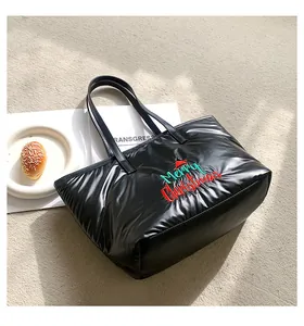 Détail d'un sac cabas matelassé noir avec broderie Merry Christmas et bonnet de fête