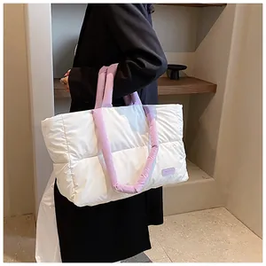 Détail d'un grand sac cabas matelassé blanc avec anses violettes et étiquette tendance